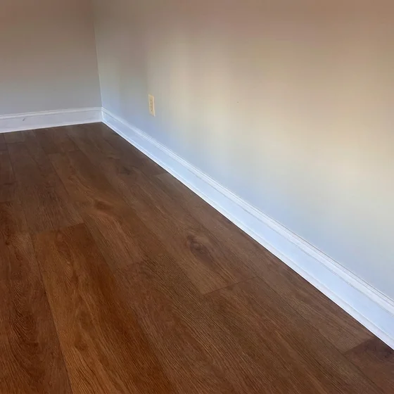 New flooring installed with baseboards painted to match