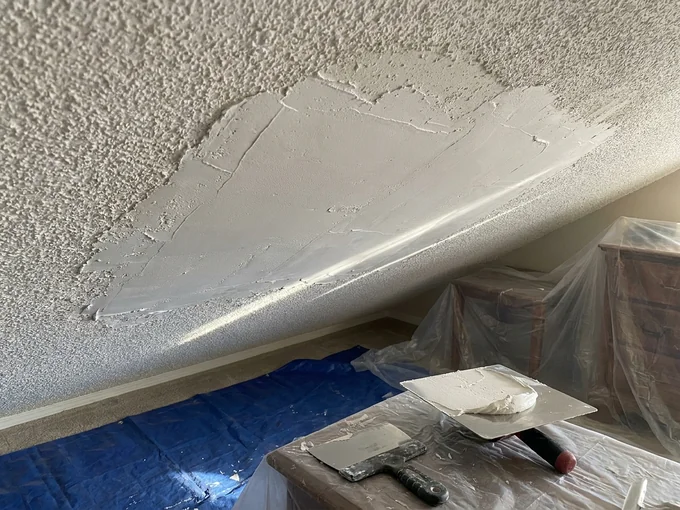 Popcorn ceiling scraped back and skim coated before the texture is rebuilt